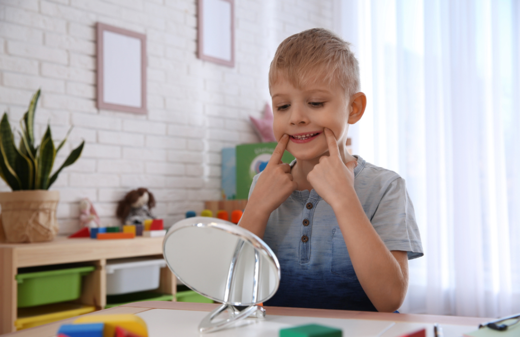 photo of a boy looking in the mirror pulling a face